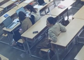 She and her classmate behind her remove heels at same time!