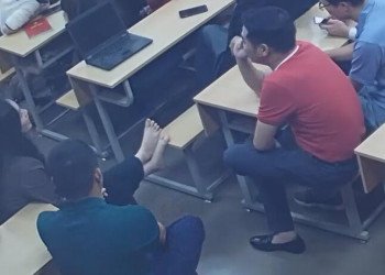 She took off her high heels to show her beautiful feet to her male classmates.