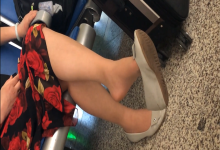 Lady in white flat dangling shoeplay when waiting for a train