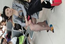 Lady dangling shoeplay when waiting for a train 22