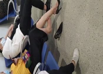 The  lady dangling shoeplay when line up in the waiting hall 163