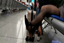 Lady remove heels relax her black nylon feet at railway station lounge