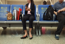 The lady remove heels relax her feet when waiting for a train
