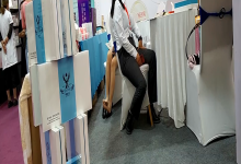 Hostess remove heels relax her tired feet in exhibition