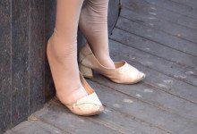 The middle-age lady dangling shoeplay when sitting on the chair