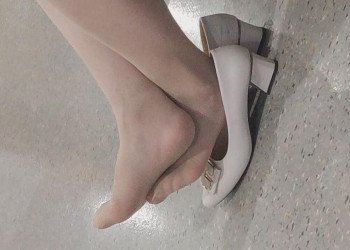 The lady remove heels and put her feet on heels have a rest