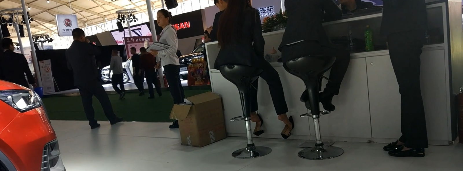 Car show hostess in highheels sit downgreat dangling shoeplay