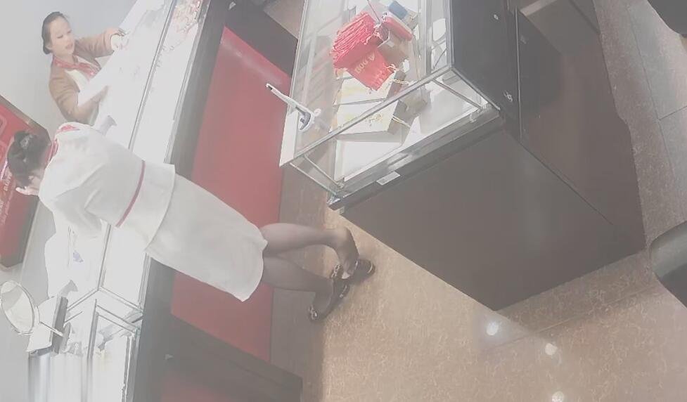 The jewelry store hostess in white dress and black nylon great danging shoeplay