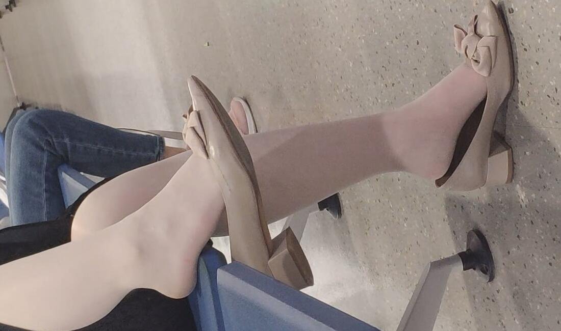 The lady dangling shoeplay in the waiting area
