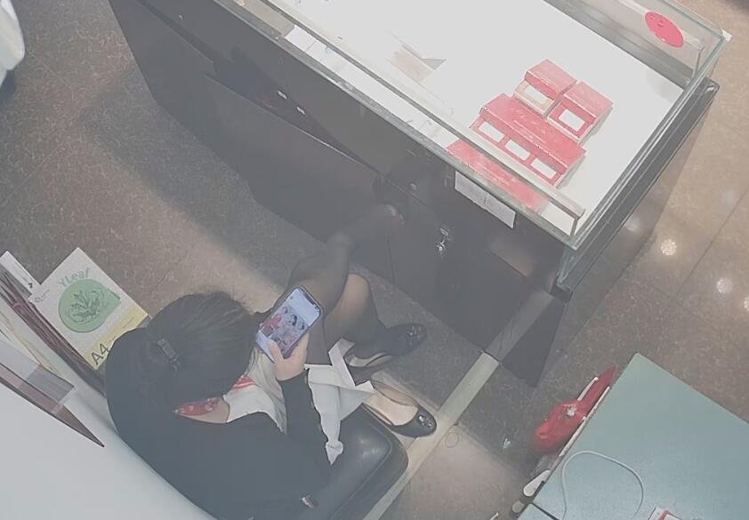 The jewelry store hostess in white dress and black nylon dangling shoeplay