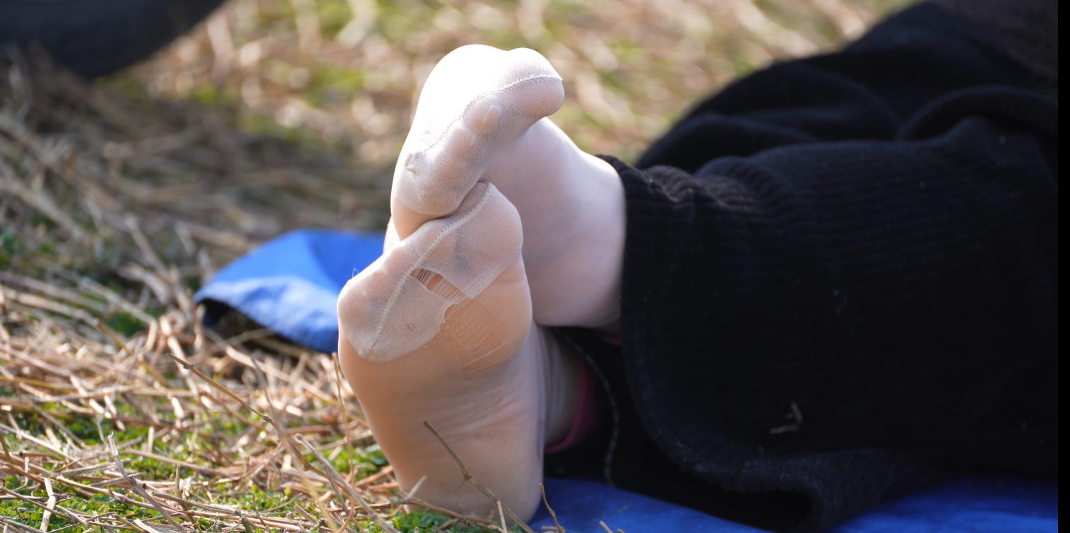 The lady remove heels relax her feet on the grass 4