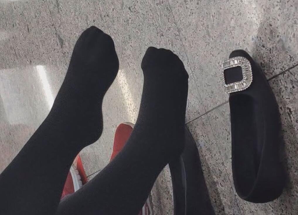 The girl black thick stockings took off her shoes to relax her feet